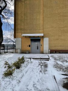 un bâtiment avec une porte dans la neige dans l'établissement Airport lux apartment 30 Self Check-In Free Parking, à Vilnius