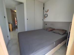 mała sypialnia z łóżkiem w pokoju w obiekcie AQUAPLAGE Joli appartement RDC piscine 1 ère ligne mer Richelieu Cap d'Agde w Cap d'Agde