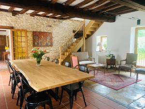 a dining room with a wooden table and chairs at Maison Céleste in Nuits-Saint-Georges