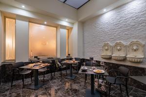 a restaurant with tables and chairs and a brick wall at La Paloma Blanca Hotel in Sciacca