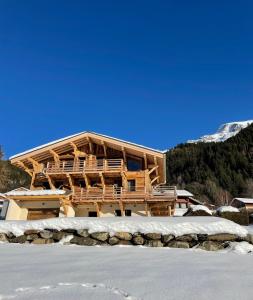 a large wooden house with snow on the ground at Chalet les 3 cerfs in Les Contamines-Montjoie