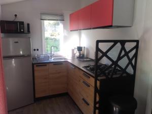 a kitchen with wooden cabinets and a white refrigerator at Camping Les Eaux Vives in Vero