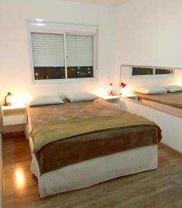 um quarto com uma cama grande e uma janela em Apartamento completo próximo aeroporto e rodoviária de POA em Canoas