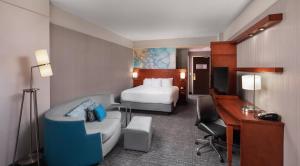 a hotel room with a bed and a desk at Courtyard by Marriott Greenville Downtown in Greenville