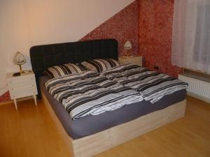 uma cama grande num quarto com uma parede vermelha em Guest House Schneider em Laatzen