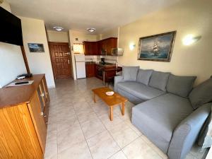 a living room with a couch and a kitchen at Pier View Los Cristianos Free WiFi in Los Cristianos
