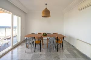 a dining room with a wooden table and chairs at Novostar Apart Monte Carlo Sea View in Sousse