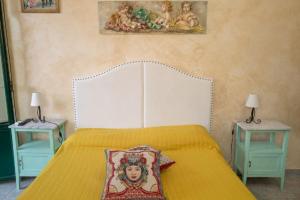 um quarto com uma cama amarela e duas mesas em Villa Gaia em Taormina