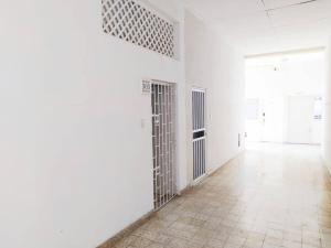 um quarto vazio com paredes brancas e um corredor com portas em apartamento centro histórico 303-1 em Cartagena das Índias