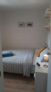 1 dormitorio con 1 cama y 1 mesa con lámpara en Apartamento moderno al pie de los Pirineos, en Sabiñánigo