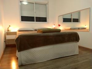 a bedroom with a large bed with two windows at Apartamento completo próximo aeroporto e rodoviária de POA in Canoas