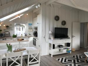 グリュックスブルクにあるFerienhaus Hein Mückのキッチン(テーブル、テレビ、カウンター付)