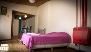 Habitación con cama con manta rosa en Verde Bosque en El Bolsón