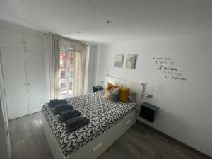 een slaapkamer met een bed met een zwart-wit dekbed bij Apartamento Playa San Lorenzo Garaje opcional in Gijón