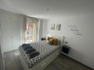 a bedroom with a bed with a black and white comforter at Apartamento Playa San Lorenzo Garaje opcional in Gijón