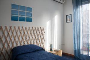 een slaapkamer met een bed met blauwe lakens en ramen bij Buona Onda in Marsala