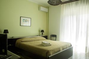una camera da letto con un letto, una scrivania e una finestra di Buona Onda a Marsala