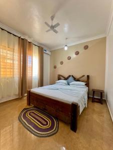Schlafzimmer mit einem Bett und einem Deckenventilator in der Unterkunft VICK Boutique Hotel in Banda Kuu