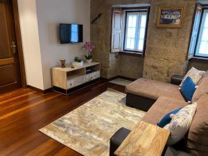 a living room with a couch and a tv at Casa Posto da Guarda Fiscal in Melgaço