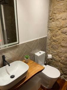 La salle de bains est pourvue de toilettes blanches et d'un lavabo. dans l'établissement Casa Posto da Guarda Fiscal, à Melgaço
