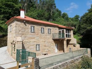 a small stone building with a balcony on it at Casa Posto da Guarda Fiscal in Melgaço