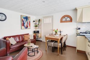 a living room with a couch and a table at 't Zwanennest in Egmond aan den Hoef +25 photos