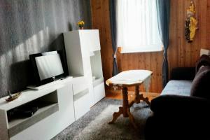 ein Wohnzimmer mit einem TV und einem Tisch in der Unterkunft Haus in Malchow in Malchow