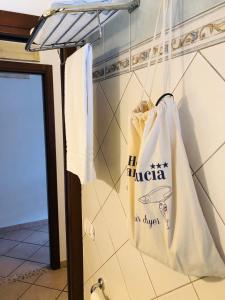 una bolsa blanca colgada en una pared en un baño en Santa Lucia, en Capo dʼOrlando