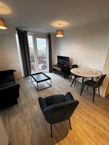 a living room with a couch and a table and chairs at Lovely 1bed apartment, Salford. in Manchester