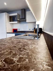 a kitchen with a sink and a counter top at Lovely 1bed apartment, Salford. in Manchester