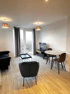 a living room with chairs and a table and a couch at Lovely 1bed apartment, Salford. in Manchester