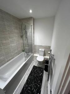 a bathroom with a shower and a toilet and a tub at Lovely 1bed apartment, Salford. in Manchester