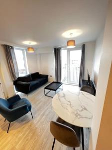 a living room with a table and some chairs at Lovely 1bed apartment, Salford. in Manchester