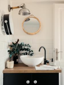 a bathroom with a bowl sink and a mirror at Kanyar - Nordic Cabin in Zebegény