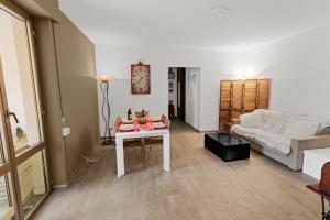 een woonkamer met een tafel en een bank bij Super logement au centre-ville in Acqui Terme