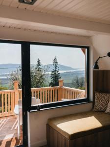 Zimmer mit einem großen Fenster mit Blick auf eine Terrasse in der Unterkunft Kanyar - Nordic Cabin in Zebegény