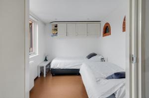 2 camas en una habitación con paredes blancas en 't Zwanennest en Egmond aan den Hoef
