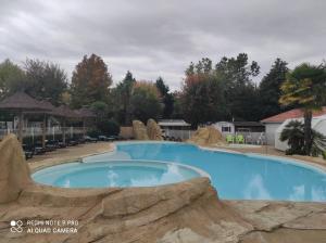 a large swimming pool at a resort at Chalet calme et agréable in Parentis-en-Born