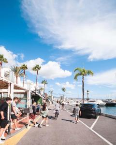 a group of people walking and riding bikes on a pier at PUERTO BANUS POL One in Marbella