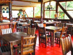 a dining room with wooden tables and chairs at Hotel Campestre El Refugio de Balsora in Filandia