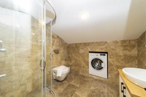 a bathroom with a toilet and a washing machine at Nature Sea View Flat with Jacuzzi in Kas Antalya in Kas