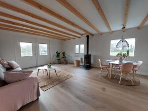 sala de estar con sofá, mesa y sillas en de Klaproos, en Noordgouwe