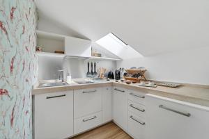 una cucina con armadietti bianchi e lucernario di Ukiyo Suites And Rooms a Cagliari