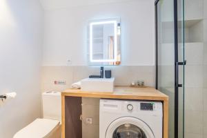 y baño con lavadora y espejo. en Sainte Baume - Patio - Linge de qualité - Fibre - Confort - Cœur de Ville, en Gardanne