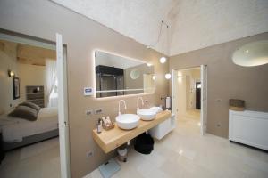 a bathroom with two sinks and a bed in a room at Dimora Palestro by MANZONI COLLECTION in Monopoli +34 photos
