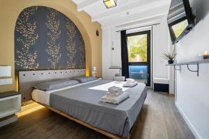 a bedroom with a large bed with towels on it at Ukiyo Suites And Rooms in Cagliari