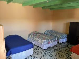 a room with two beds in a room at Hostal Tuyasto in San Pedro de Atacama