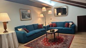 a living room with two blue couches and a table at Hotel Roma in Bologna