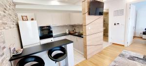 a kitchen with white cabinets and a black counter top at Extra Apartment town centre in Banja Luka
