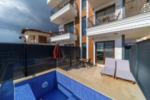 a balcony of a house with a swimming pool at Sea and Nature View Cozy Flat with Pool in Kas in Kas
